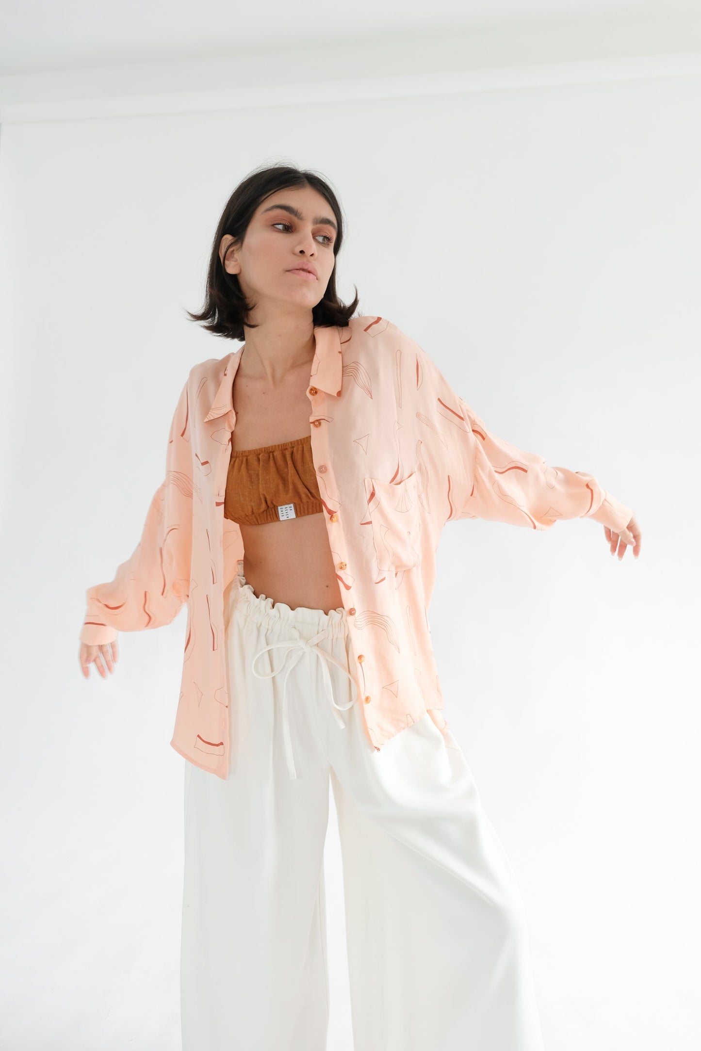 Girl wearing pink silk printed shirt and white trousers