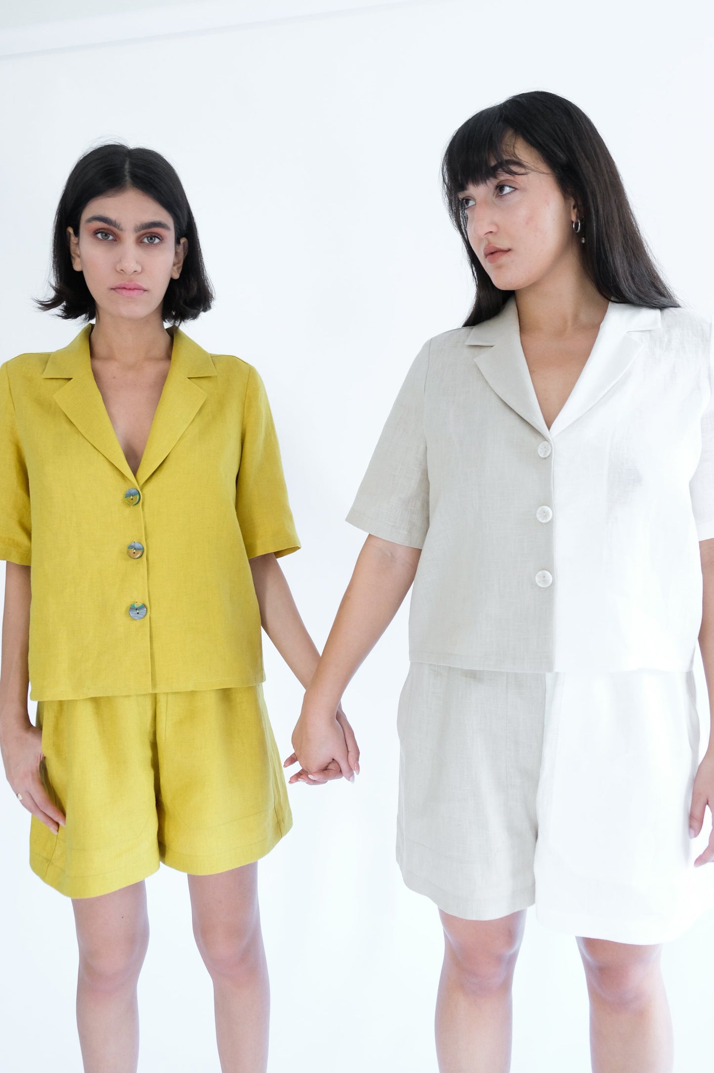 Two girls holding hand wearing yellow shirts and shorts 