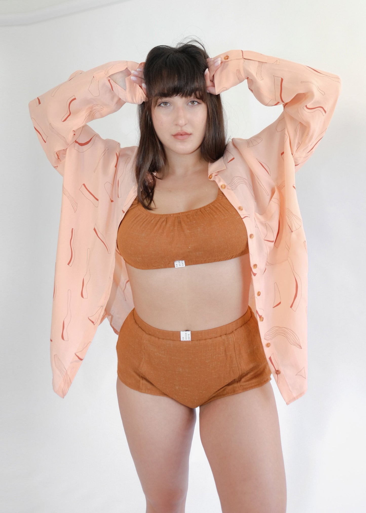 Standing girl wearing pink shirt and brown underwear set